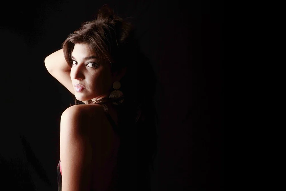 Retrato de perfil con luz cálida sobre fondo oscuro